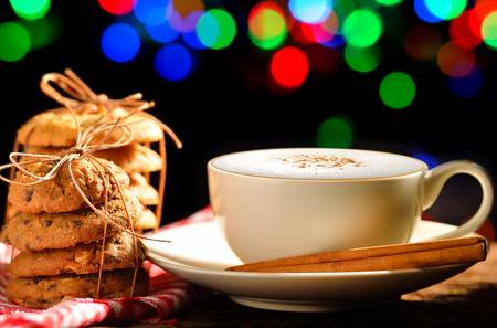 A cup of cappuccino and cookies in festive surroundingの写真素材
