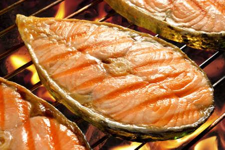 Pieces of salmon on flaming grillの写真素材