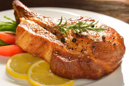 Grilled pork chop and vegetable saladの写真素材