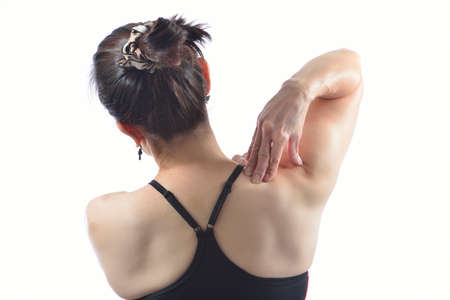 Woman pressing her hand against a painful shoulder 