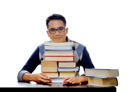 Young smiling student with stack of booksの写真素材