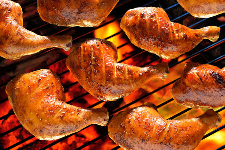 Grilled chicken thigh on the flaming grillの写真素材