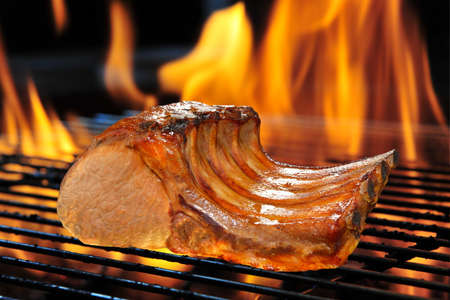 Grilled pork chop on the flaming grill の写真素材