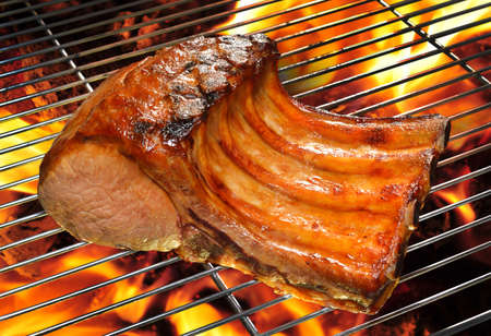 Grilled pork chop on the flaming grill の写真素材
