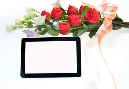 Tablet computer and beautiful bouquet of flowers isolated on whiteの写真素材