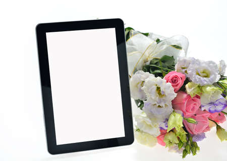 Tablet computer and beautiful bouquet of flowers isolated on whiteの写真素材