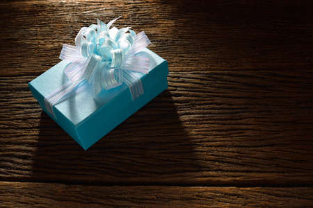 Gift box with ribbon on old wooden backgroundの写真素材