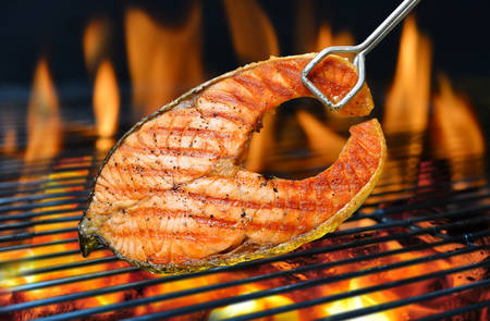 Grilled salmon on the flaming grillの写真素材