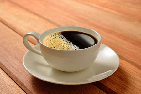 A cup of coffee on wooden backgroundの写真素材