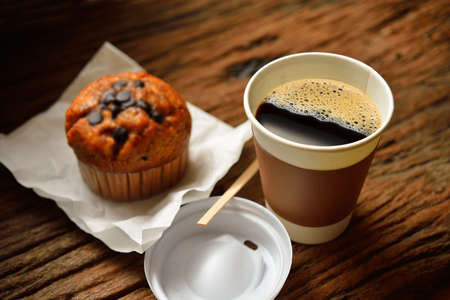 Paper cup of coffee and cake on wooden backgroundの写真素材
