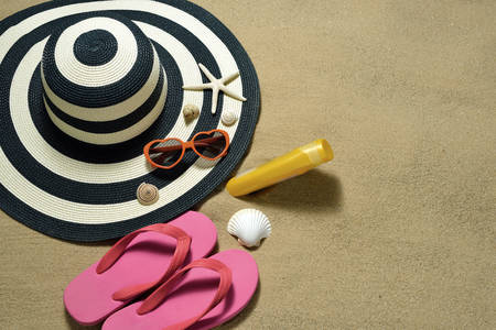 Beach accessories with starfish and seashells on sandy beach