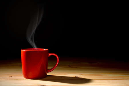 Cup of coffee with smoke on old wooden backgroundの写真素材