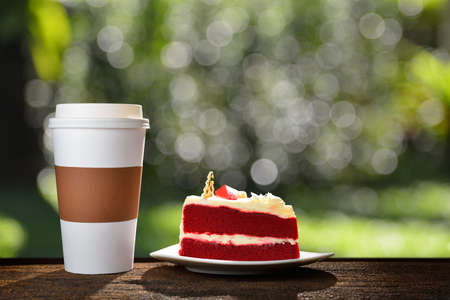 Paper cup of coffee and cake in the gardenの写真素材
