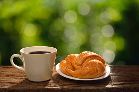 Morning cup of coffee and croissant in the garden,copy space backgroundの写真素材