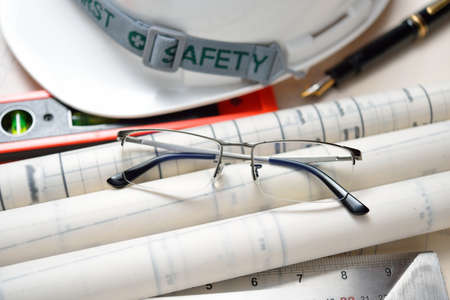 Businessman eyeglasses with construction plans at construction siteの写真素材