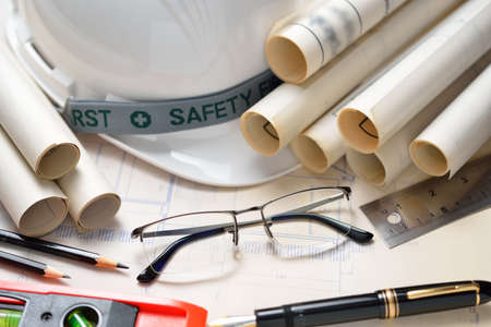 Businessman eyeglasses with construction plans at construction siteの写真素材