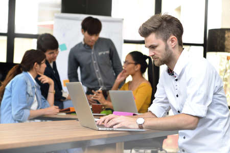 Young businessman working in the office with a laptop computerの写真素材