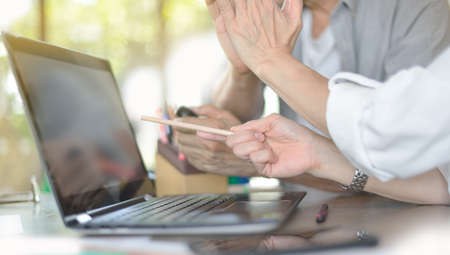Businesspersons discussing and pointing at screen in office