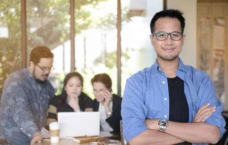 Young businessman smiling at camera in office