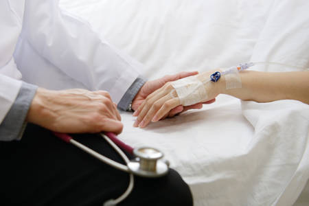 Medical doctor holing patient's hand and comforting herの写真素材