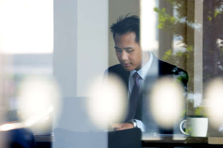 Young Asian businessman  working with laptop computer in coffee shop