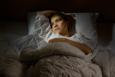 Woman with insomnia lying in bed with open eyesの写真素材