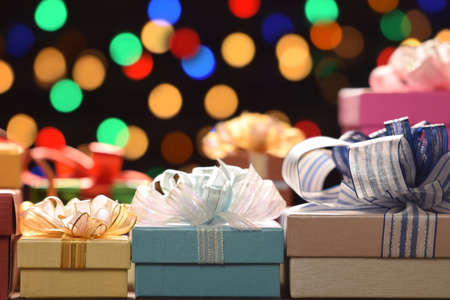 Mixture of gift boxes topped with ribbons on bokeh background