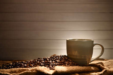 Coffee cup and coffee beans on old wooden backgroundの写真素材