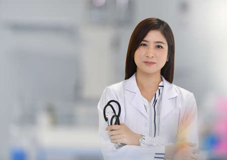 Smiling Asian medical doctor woman with stethoscope in hospital with copy spaceの写真素材