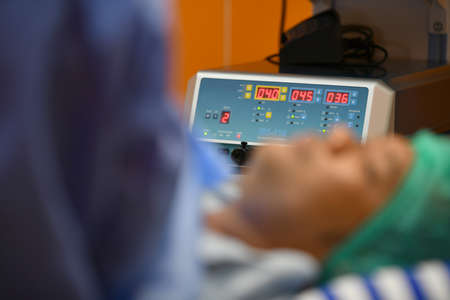 Surgeon inspecting a cardiogram when treating patientの写真素材