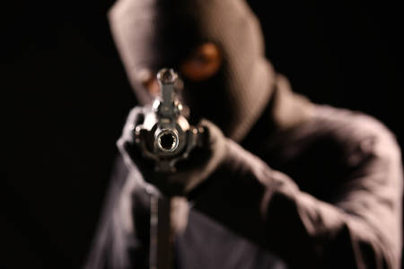 The Robber aiming rifle on black backgroundの写真素材