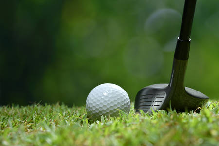 Golf ball on green grass ready to be struck on golf course backgroundの写真素材