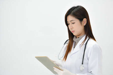 Smiling Asian medical doctor woman with stethoscope isolated on white backgroundの写真素材