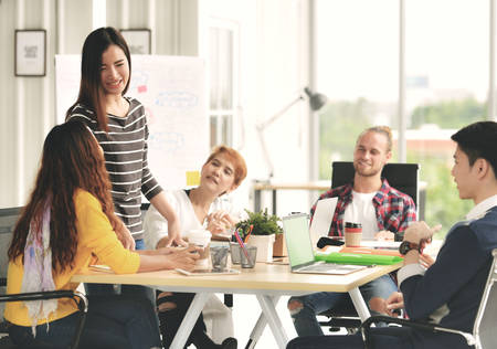 Young businesswoman leading a meeting in casual setting at office