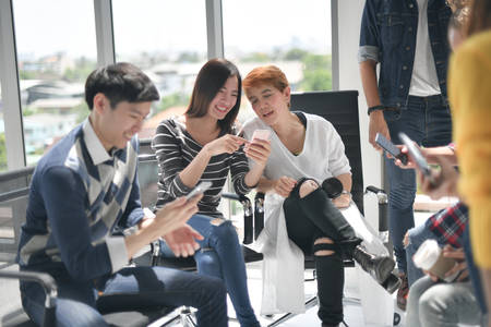 Group of businesspersons discussing and using electronic devices at the officeの写真素材