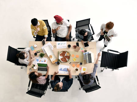 Group of young businesspersons having discussion and sharing opinions in meeting at officeの写真素材