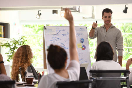 Business man giving presentation on future plans to his colleagues at an office