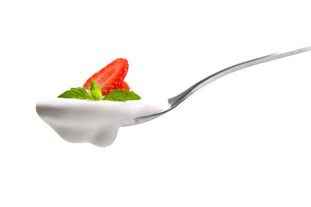 Plain yogurt on a spoon with fresh strawberry on top isolated on white backgroundの写真素材