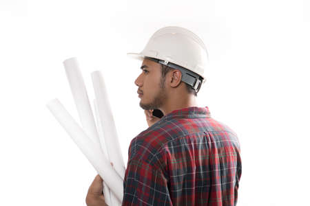 Portrait of asian engineer holding blueprint and using a cellphone isolated on white
