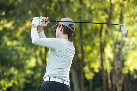 Asian woman playing golf on a beautiful natural golf courseの写真素材