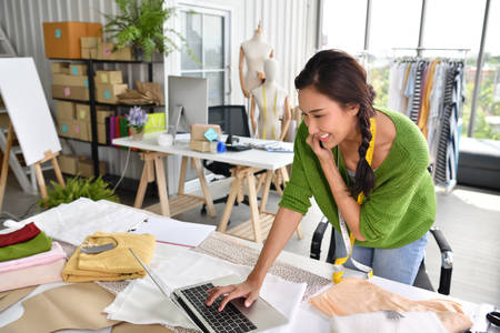 Young Asian woman entrepreneur / fashion designer working in studioの写真素材