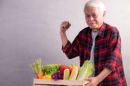 Healthy Asian senior man with crate full of fruits and vegetablesの写真素材