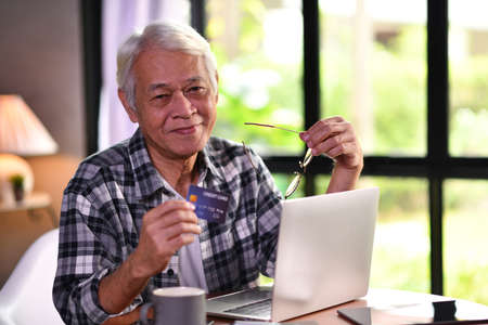 Asian senior man using credit card for online shoppingの写真素材