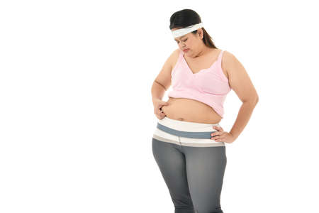 Overweight Asian woman pinching belly fat isolated on white backgroundの写真素材