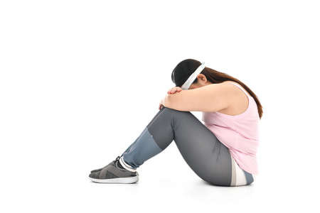 Overweight Asian woman sitting on the floor looking sad isolated on white backgroundの写真素材