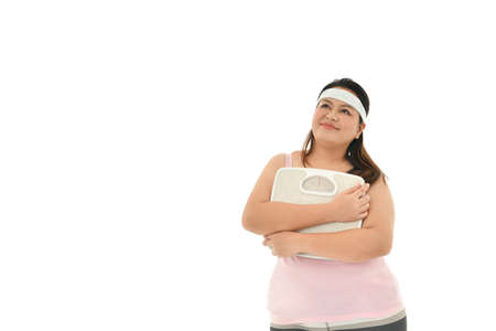 Overweight Asian woman with scale isolated on white backgroundの写真素材