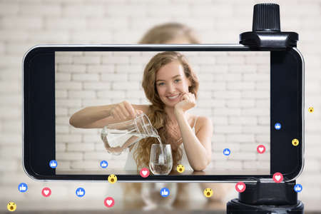 Young female blogger and vlogger and online influencer live streaming a healthy lifestyle on social...