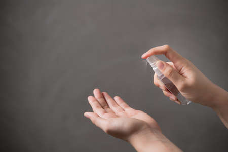 Hands spraying alcohol hand sanitizer for disinfection hygiene and protection against CORONAVIRUS (COVID-19)の写真素材