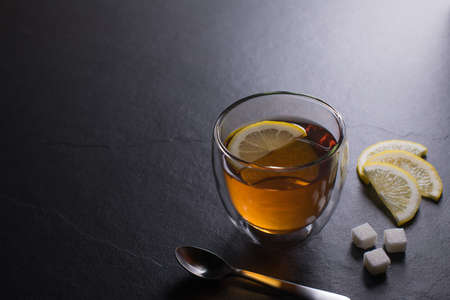 Cup of tea with lemon on black granite backgroundの写真素材