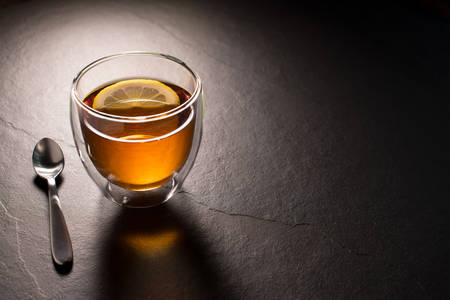 Cup of tea with lemon on black graniteの写真素材